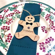 Load image into Gallery viewer, Napkin holder shaped like a gingerbread man with 'Grandpa' engraved, on a blue napkin with a decorative plate in the background.