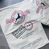 Load image into Gallery viewer, santa sack with postal-themed design on a gray wooden floor