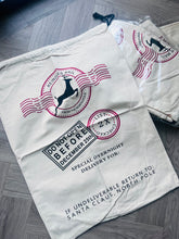 Load image into Gallery viewer, santa sack with postal-themed design on a gray wooden floor