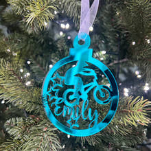 Load image into Gallery viewer, A blue mirrored acrylic Christmas tree decoration with the text 'BMX' and a star cut-out, hanging from a tree with lights and green needles in the background.