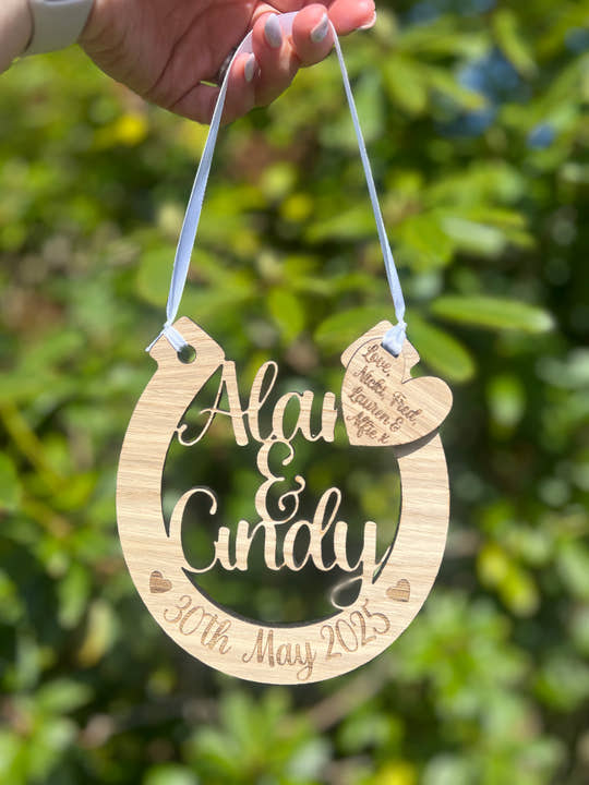 Personalised oak wooden wedding horseshoe engraved with names and wedding date, perfect as a bridal bouquet charm or keepsake gift.
