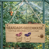 Load image into Gallery viewer, Personalised wooden sign reading “Grandad’s Greenhouse – Little Helpers Welcome” with a plant pot labelled Daisy and Lily, hanging inside a bright greenhouse with stone flooring and tomato plant