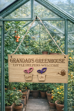 Load image into Gallery viewer, Personalised wooden sign reading “Grandad’s Greenhouse – Little Helpers Welcome” with a plant pot labelled Daisy and Lily, hanging inside a bright greenhouse with stone flooring and tomato plant
