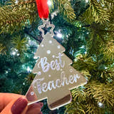 Load image into Gallery viewer, Decorative ornament shaped like a tree with 'Best Teacher' text, held in front of a Christmas tree.