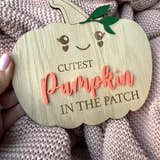 Load image into Gallery viewer, Wooden pumpkin-shaped sign with 'Cutest Pumpkin in the Patch' text on a textured fabric background