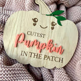 Load image into Gallery viewer, Wooden pumpkin-shaped sign with 'Cutest Pumpkin in the Patch' text on a textured fabric background
