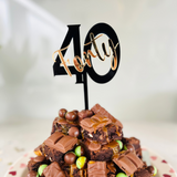 Load image into Gallery viewer, A cake topper with the number 40 in black, placed on a chocolate cake with candies.