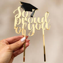 Load image into Gallery viewer, Gold mirrored acrylic graduation cake topper with black graduation cap, handmade in the UK, displayed by hand against a neutral background.