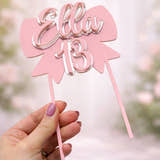 Load image into Gallery viewer, Pink cake topper with 'Ella 13' held by a hand against a blurred background