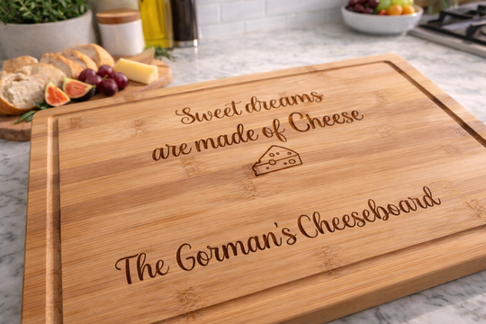 Wooden cheeseboard with engraved text on a kitchen counter.