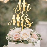 Load image into Gallery viewer, Gold mirror acrylic Mr and Mrs wedding cake topper on a white buttercream wedding cake with blush roses and greenery.