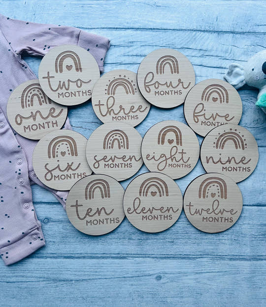 Personalised wooden baby milestone discs with rainbow theme, engraved with baby's milestones. Perfect for newborn gifts, baby showers, and capturing special moments.