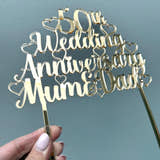 Load image into Gallery viewer, Golden wedding cake topper in gold mirror acrylic with heart details, held up to the light