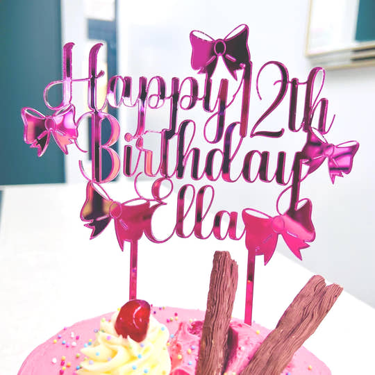 A personalised acrylic birthday cake topper featuring a custom name and age, beautifully designed with elegant bow details. The topper is made from vibrant pink acrylic, perfect for adding a stylish and unique touch to any birthday cake