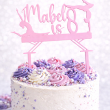 Load image into Gallery viewer, Personalised pink acrylic gymnastics birthday cake topper with custom name and age on white cake decorated with purple and pink buttercream swirls and sprinkles.