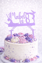 Load image into Gallery viewer, Personalised lilac acrylic gymnastics birthday cake topper with custom name and age on white cake decorated with purple and pink buttercream swirls and sprinkles.