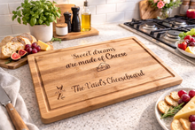 Load image into Gallery viewer, Custom engraved bamboo cheeseboard with personalised names and cheese quote on modern kitchen countertop.
