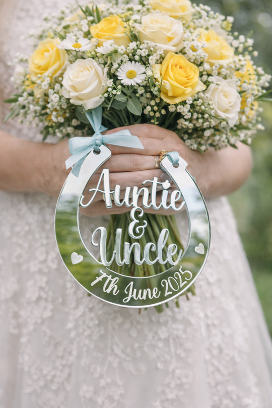 Silver mirror personalised wedding horseshoe engraved Auntie & Uncle 7th June 2025 hanging from yellow and white bridal bouquet