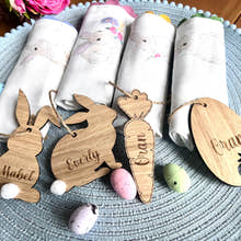 Load image into Gallery viewer, A set of four wooden hanging Easter decorations including cut-out bunny shapes and egg designs, displayed on a table with Easter eggs and fabric.