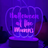 Load image into Gallery viewer, A personalised LED light up stand with a pumpkin shape, illuminated in purple and with the text 'HALLOWEEN AT THE MINNS' engraved on it.