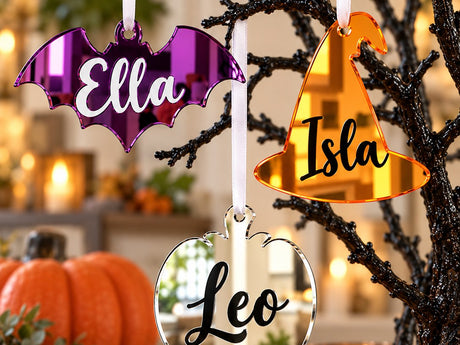 Personalised Halloween tree decorations: a purple bat Ella, an orange witch hat Isla and a silver pumpkin Leo