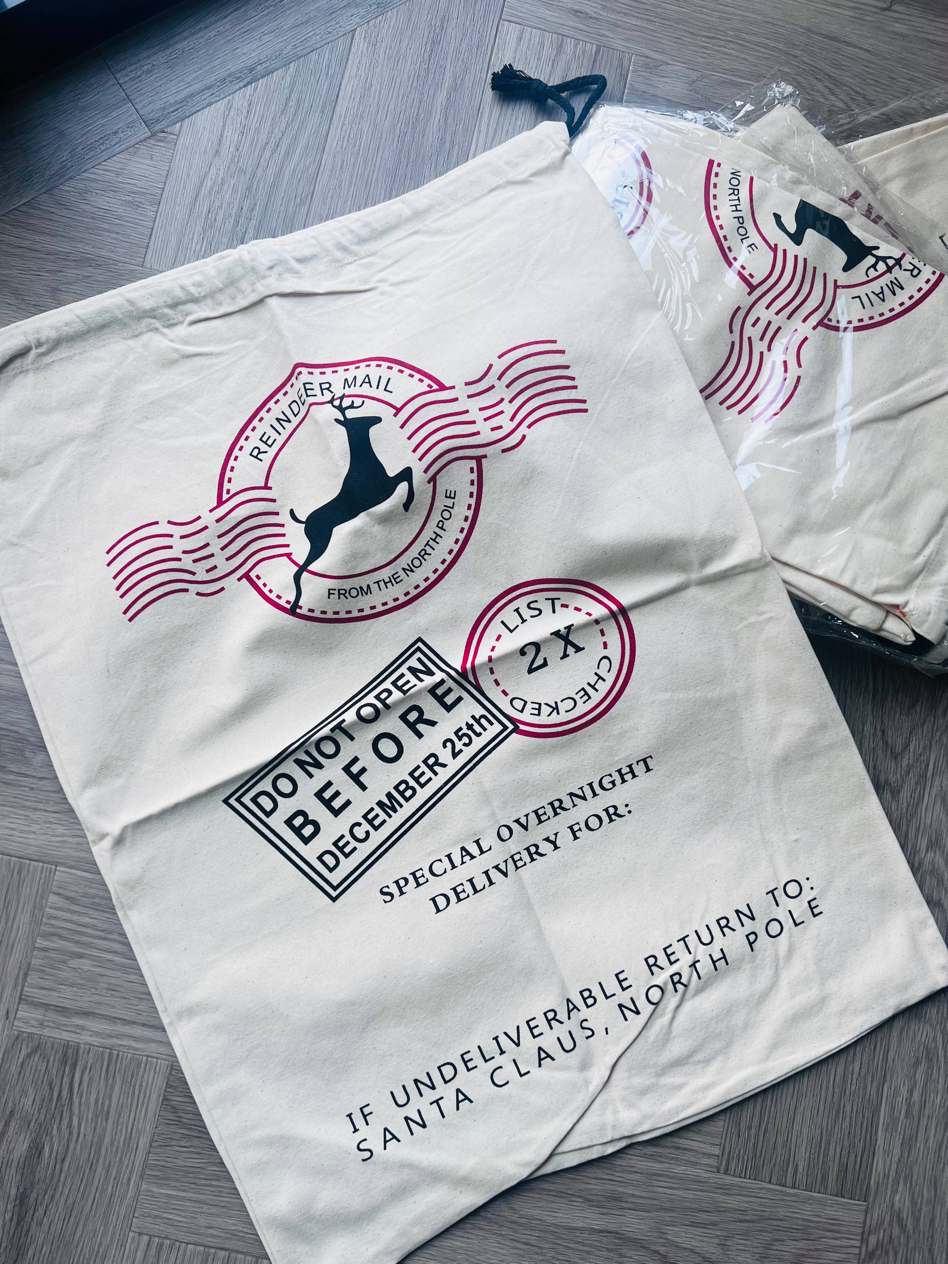 santa sack with postal-themed design on a gray wooden floor