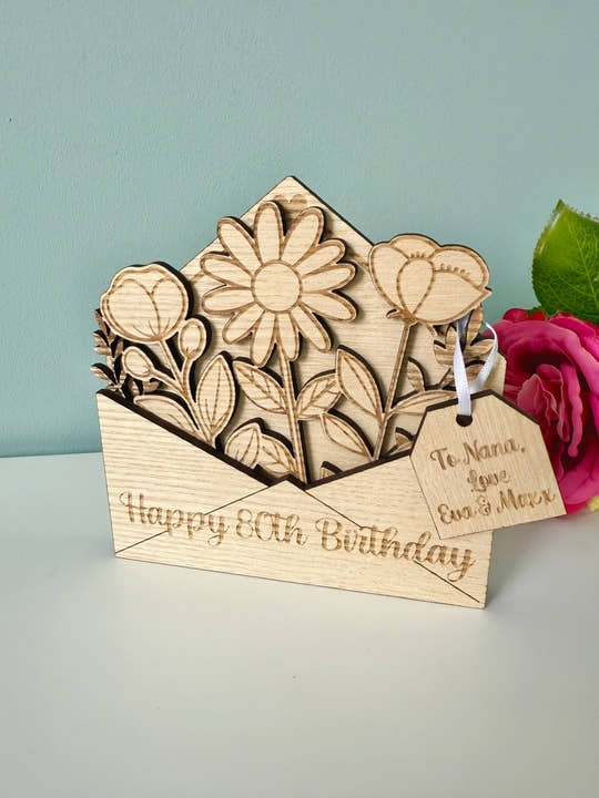 Wooden birthday card with floral design and pink rose on a light gray background