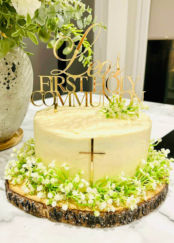 A ROUND WHITE CAKE DECORATED WITH WHITE FLOWERS AND TOPPED WITH PERSONALISED GOLD Acylic cake topper