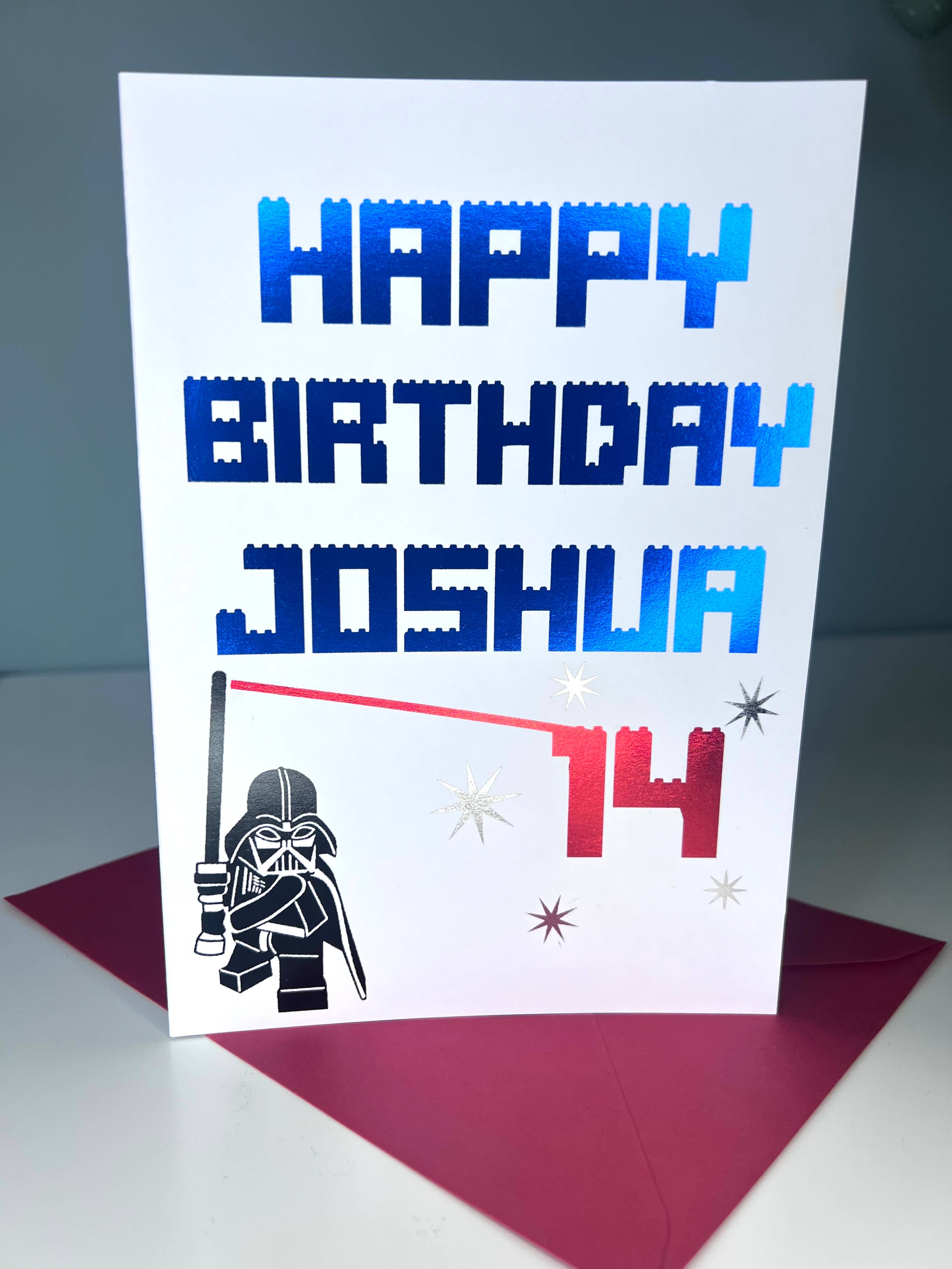 A personalized birthday card with the name Joshua and the age 14, featuring a graphic of Darth Vader and birthday cake candles.