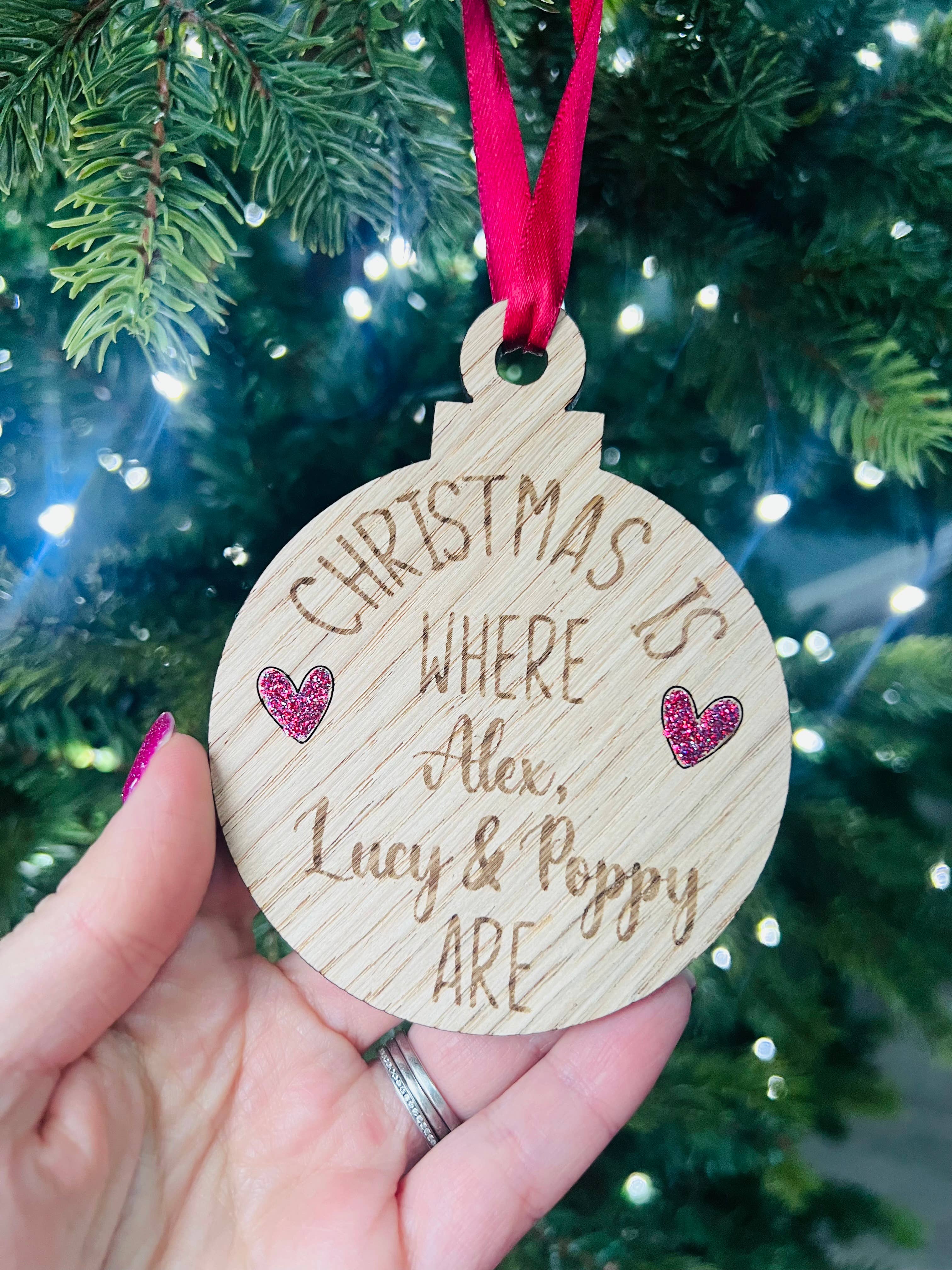 A personalized oak veneer Christmas decoration with the text 'Christmas is where.