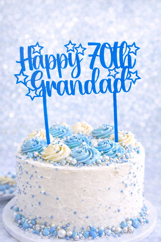 Birthday cake with blue and white frosting and 'Happy 70th Grandad' topper on a light blue background
