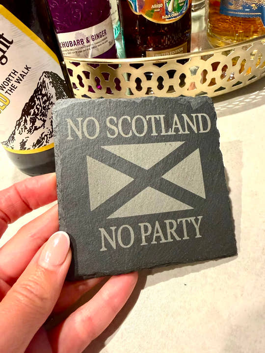 Coaster with 'No Scotland, No Party' text and Scottish flag held by a hand, with drinks in the background.