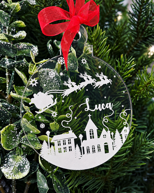 Personalised Christmas bauble with Santa and reindeer, snowy village, stars and name Luca on clear acrylic