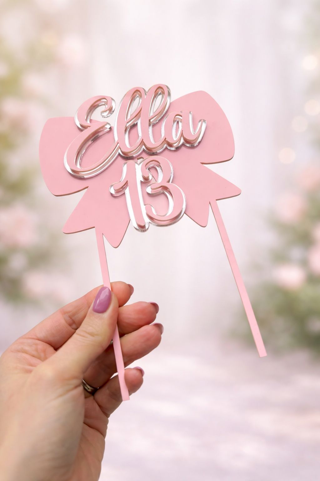 Load image into Gallery viewer, Pink cake topper with 'Ella 13' held by a hand against a blurred background
