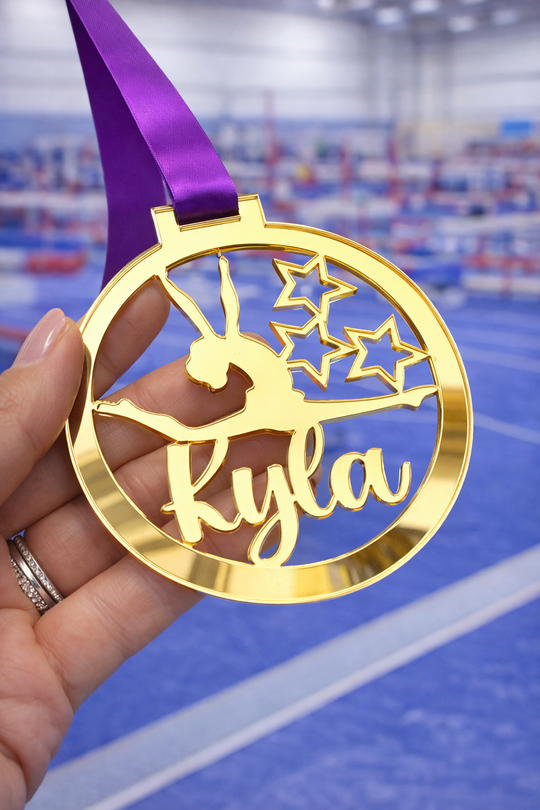 gold mirror acrylic personalised gymnastics medal held in hand with custom name design