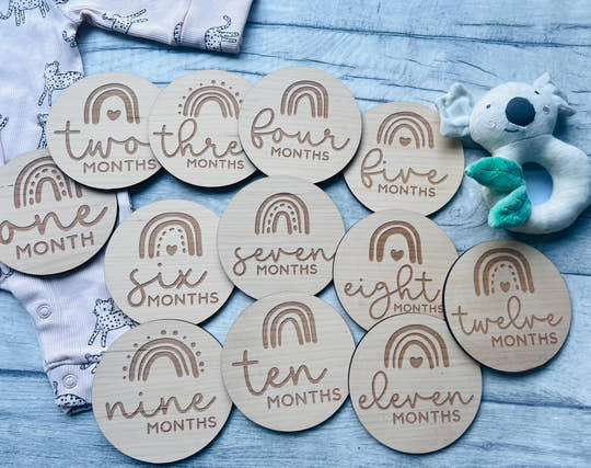 Personalised wooden baby milestone discs with rainbow theme, engraved with baby's milestones. Perfect for newborn gifts, baby showers, and capturing special moments.