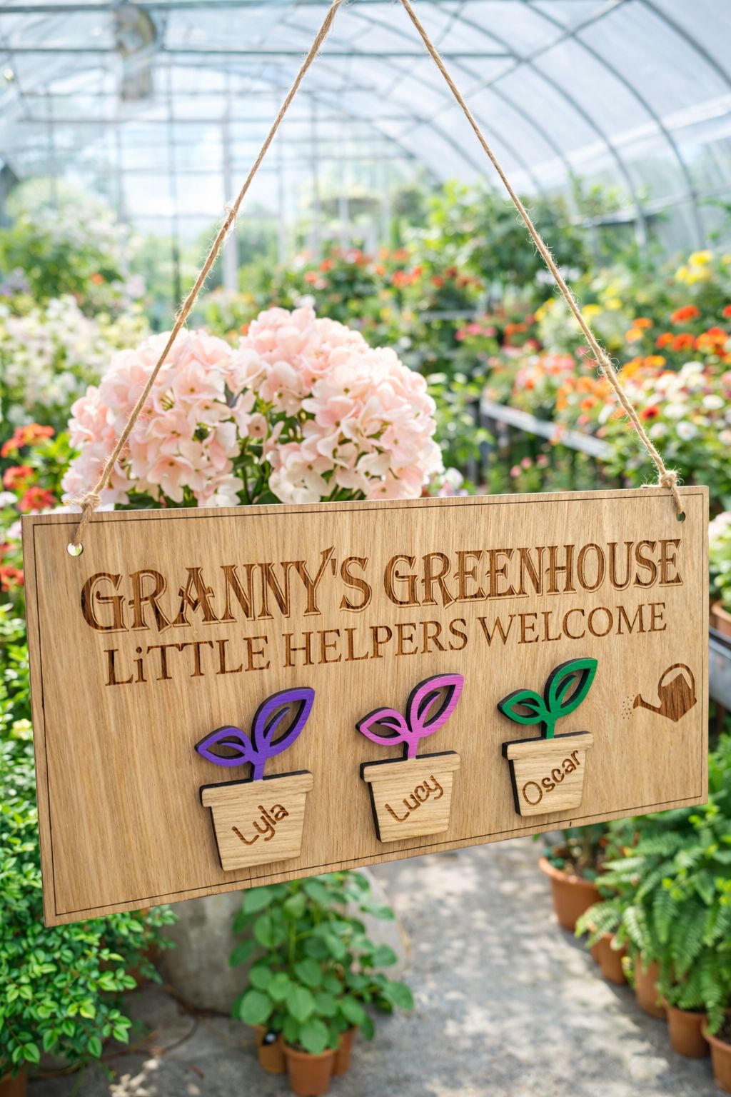 Load image into Gallery viewer, Personalised Grandad’s Greenhouse wooden sign with little helpers welcome text and Theo plant pot design hanging in a FLOWER illed greenhouse.
