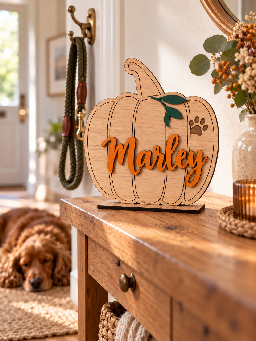 Load image into Gallery viewer, Personalised oak pet pumpkin with the name Marley on a hallway table with a sleeping dog
