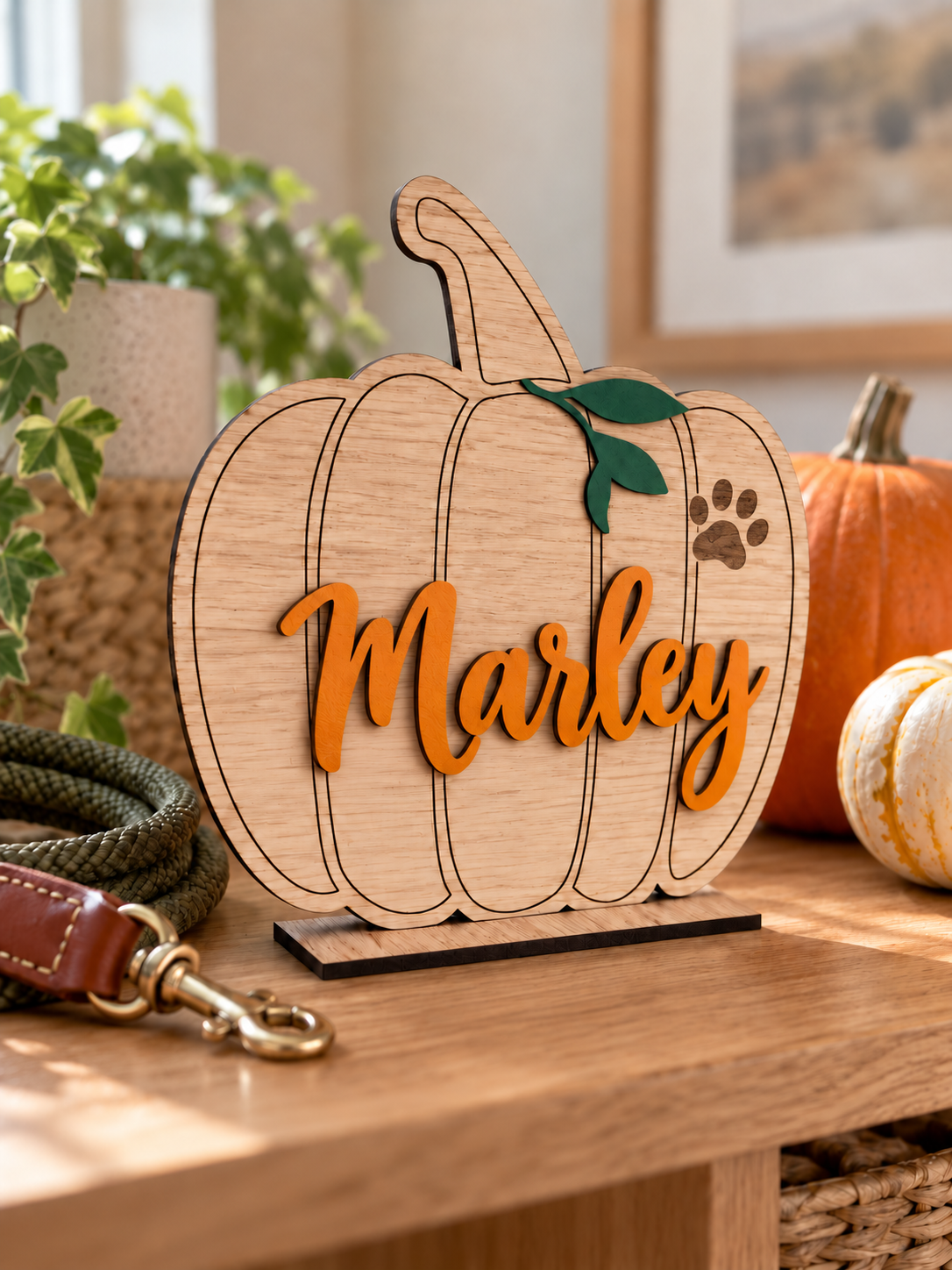 Load image into Gallery viewer, Personalised oak pet pumpkin Halloween decoration with an engraved paw print and the name Marley in orange
