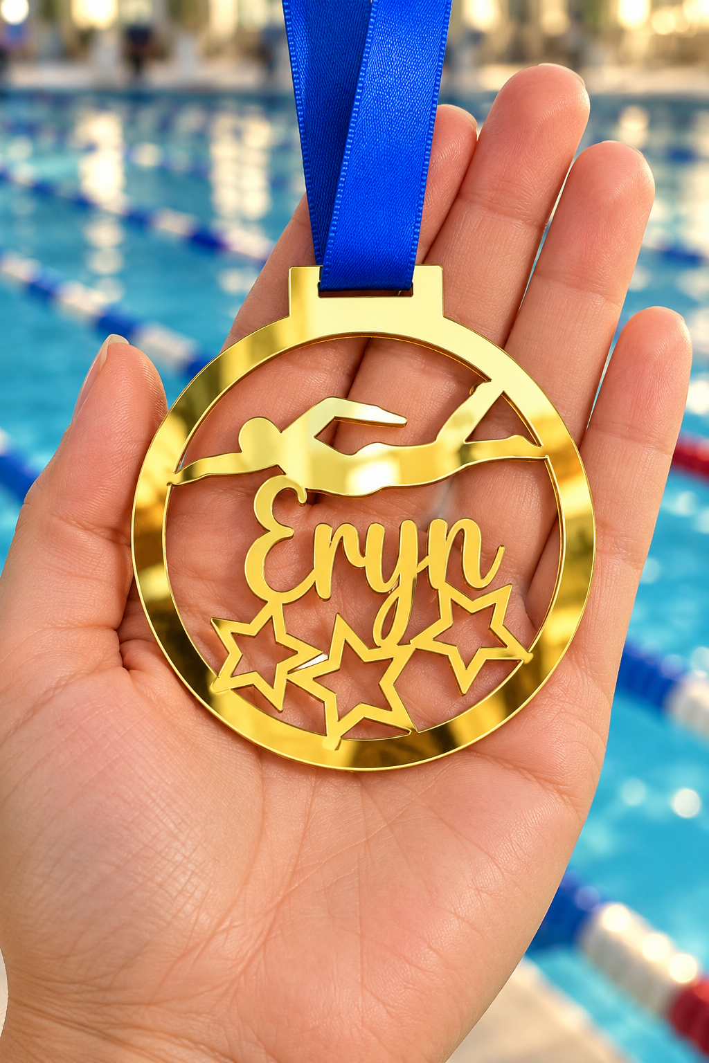 Load image into Gallery viewer, gold mirror acrylic personalised swimming medal with custom name on a blue ribbon, held in hand in front of a blurred swimming pool
