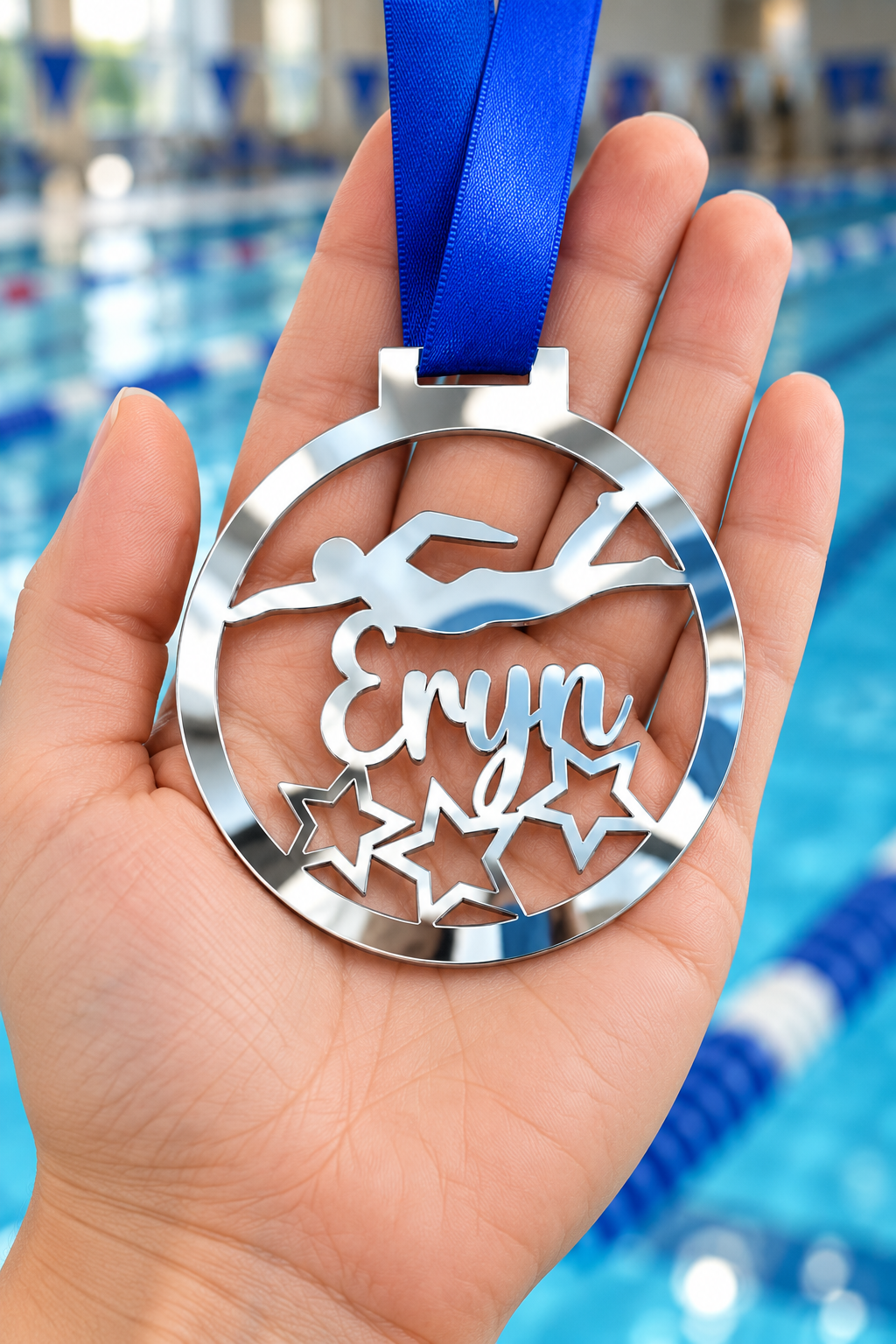 Load image into Gallery viewer, silver mirror acrylic personalised swimming medal with custom name on a blue ribbon, held in hand in front of a blurred swimming pool
