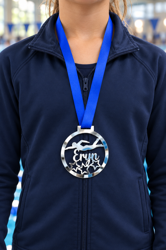 silver mirror acrylic personalised swimming medal on a blue ribbon worn around the neck