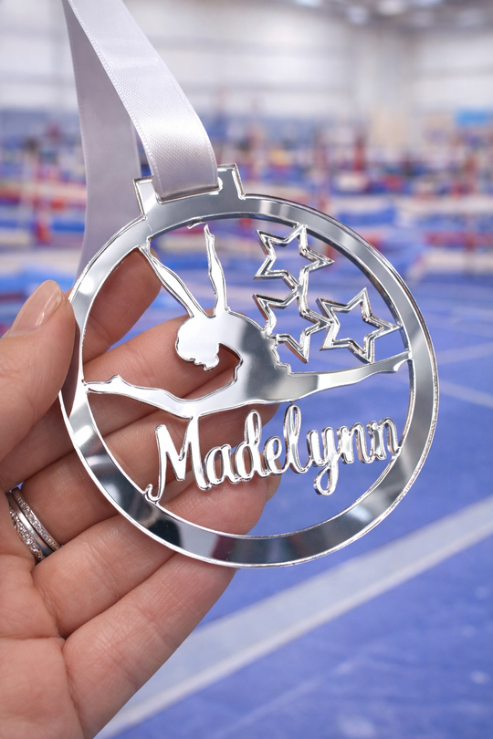 silver mirror acrylic personalised gymnastics medal held in hand with custom name design