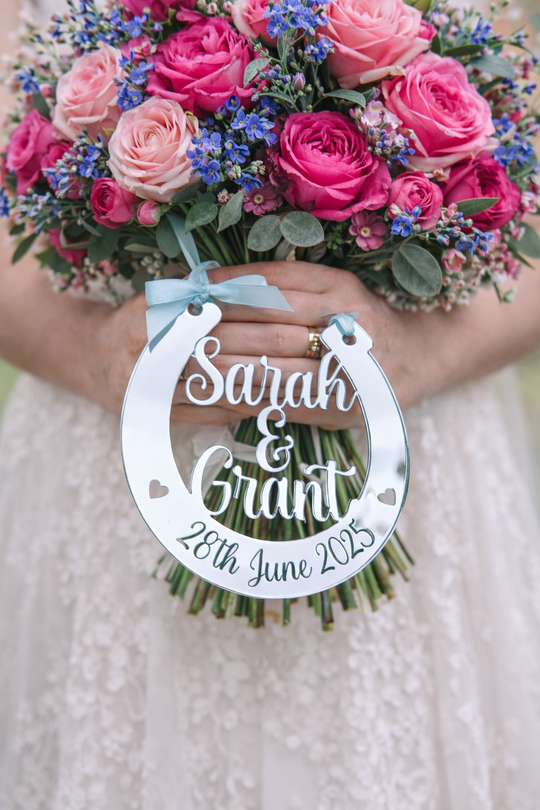 Personalised silver mirror wedding horseshoe hanging from bridal bouquet engraved Sarah & Grant 28th June 2025